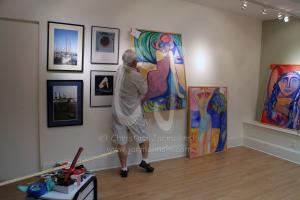 Rob de Koter hanging the paintings and his photographs